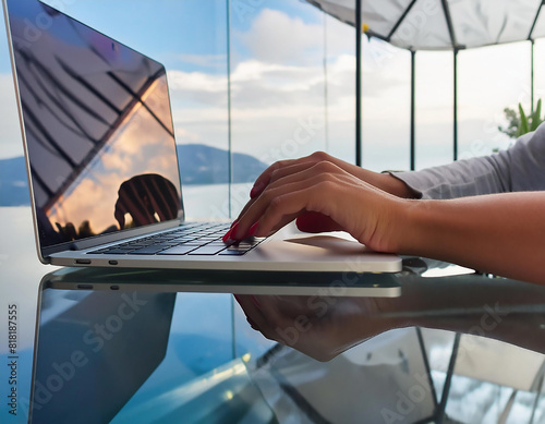 Mano di una donna che digita su una tastiera di laptop con riflessi  photo