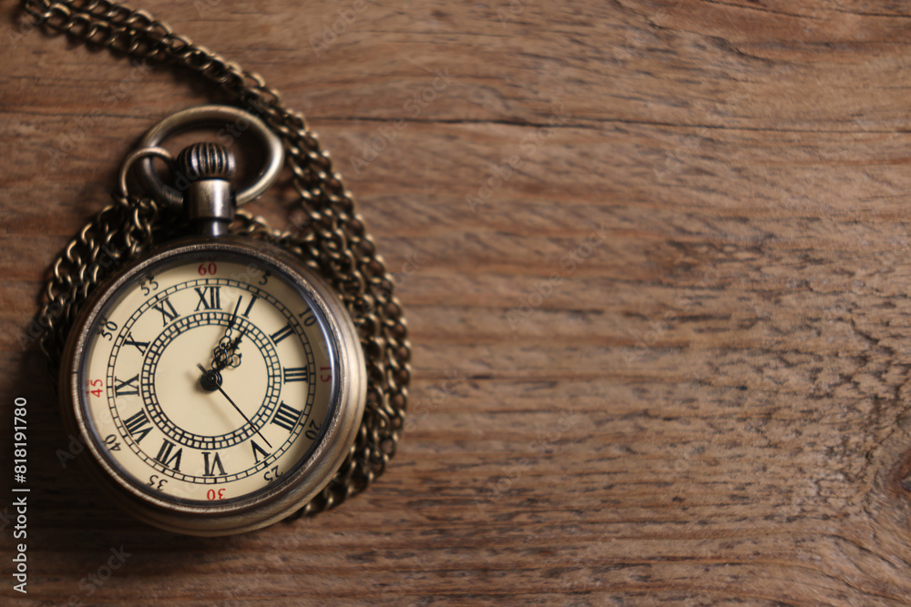 Pocket clock with chain on wooden table, top view. Space for text Pocket clock with chain on wooden table, top view. Space for text