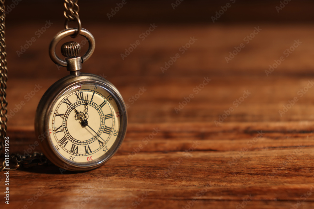 Pocket clock with chain on wooden table, closeup. Space for text Pocket clock with chain on wooden table, closeup. Space for text