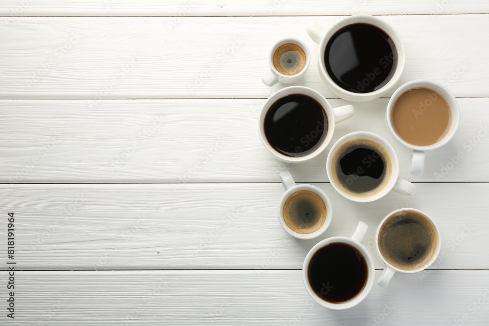 Different coffee drinks in cups on white wooden table, flat lay. Space for text Different coffee drinks in cups on white wooden table, flat lay. Space for text
