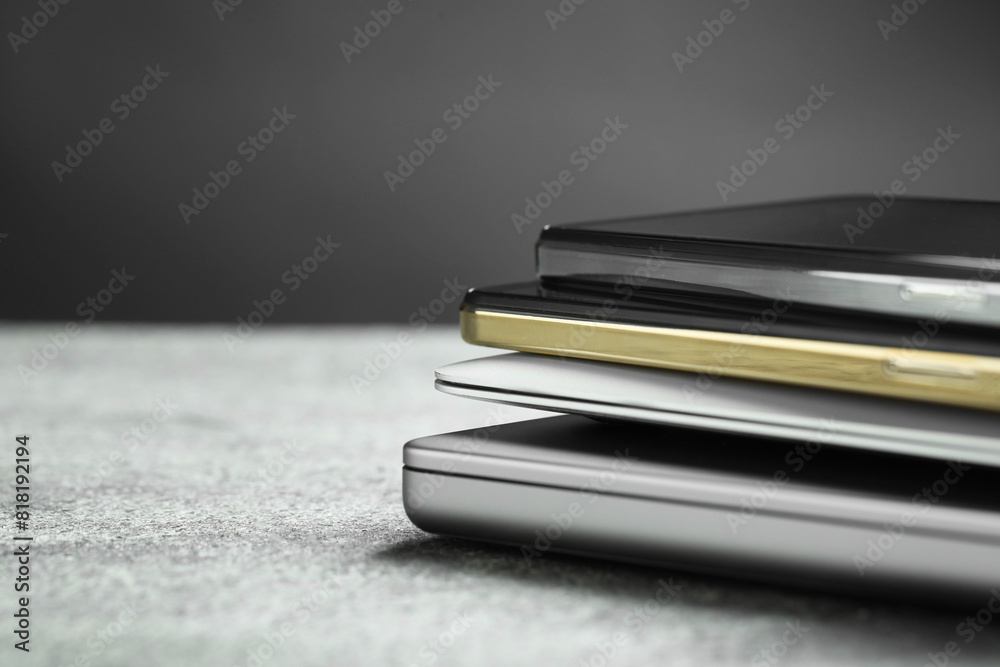 Stack of electronic devices on grey table, closeup. Space for text Stack of electronic devices on grey table, closeup. Space for text
