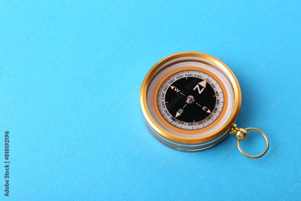 Compass on light blue background, space for text. Navigation equipment Compass on light blue background, space for text. Navigation equipment