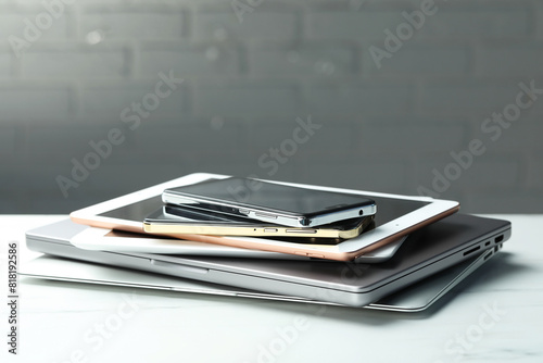 Stack of electronic devices on white table, closeup. Space for text