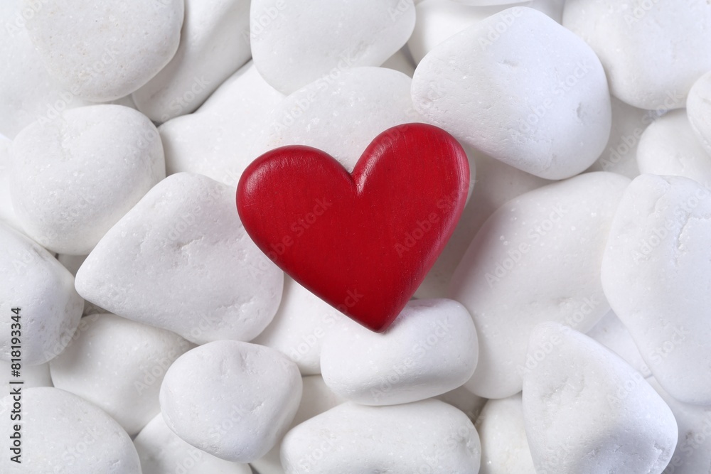 Obraz premium Decorative heart on white pebble stones, top view