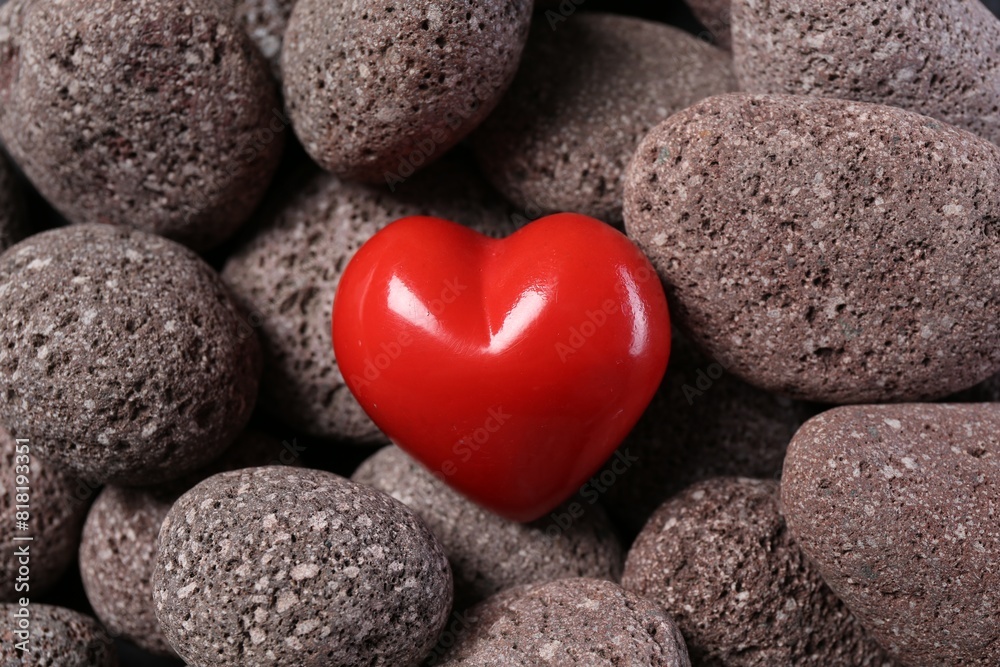 One red decorative heart on stones, above view