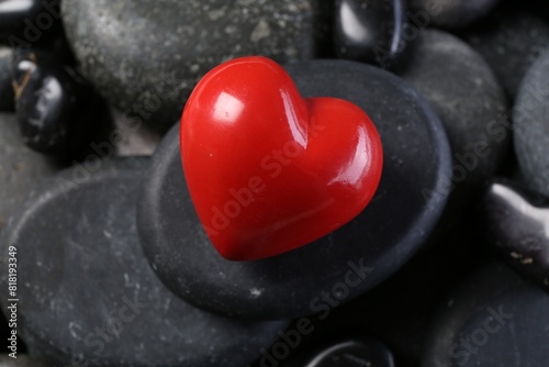 Red decorative heart on pebble stones, closeup