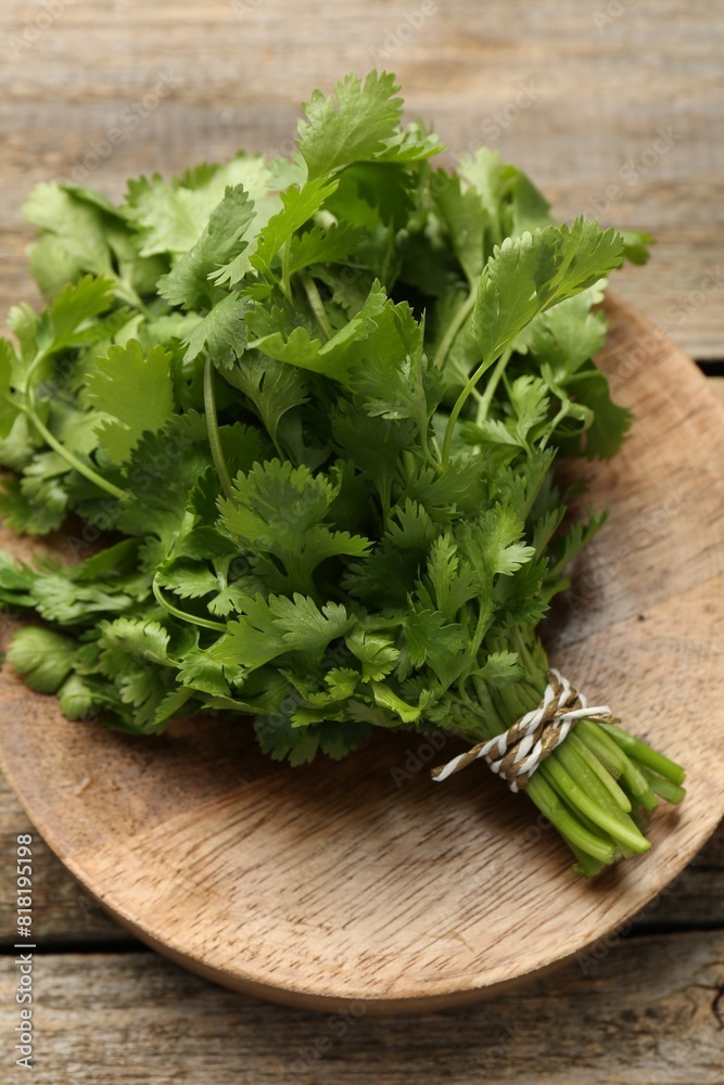 Bunch of fresh coriander on wooden table, top view Bunch of fresh coriander on wooden table, top view