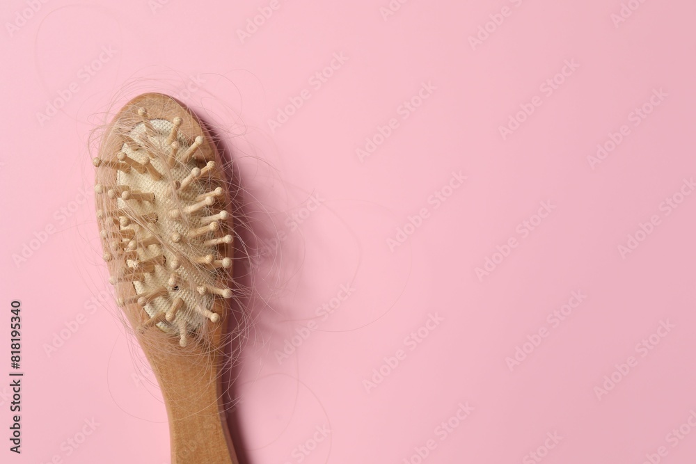 Wooden brush with lost hair on pink background, top view. Space for text Wooden brush with lost hair on pink background, top view. Space for text