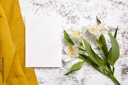 Blank card mockup with alstroemeria flowers on white painted wood with yellow fabric, flat lay © mikeosphoto