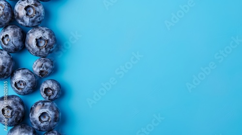  A cluster of blueberries arranged on a blue backdrop, awaiting text inscription