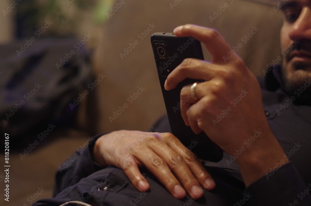 Obraz premium close up of a married man with a ring holding mobile phone in his hands
