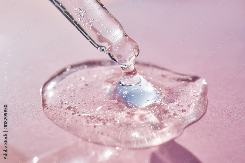 Pipette with serum shimmering in the sun on a pink background. Pipette with serum shimmering in the sun on a pink background.
