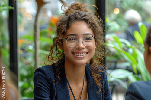 A young professional woman with curly hair and glasses. Created with Ai