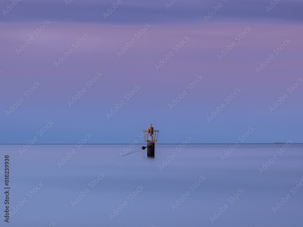 Sea buoy on the background of the sunset on the Baltic coast