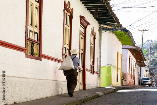 Senior local man walking at the beautiful streets at the historical downtown of the heritage town of Salamina located at the Caldas department in Colombia. photo