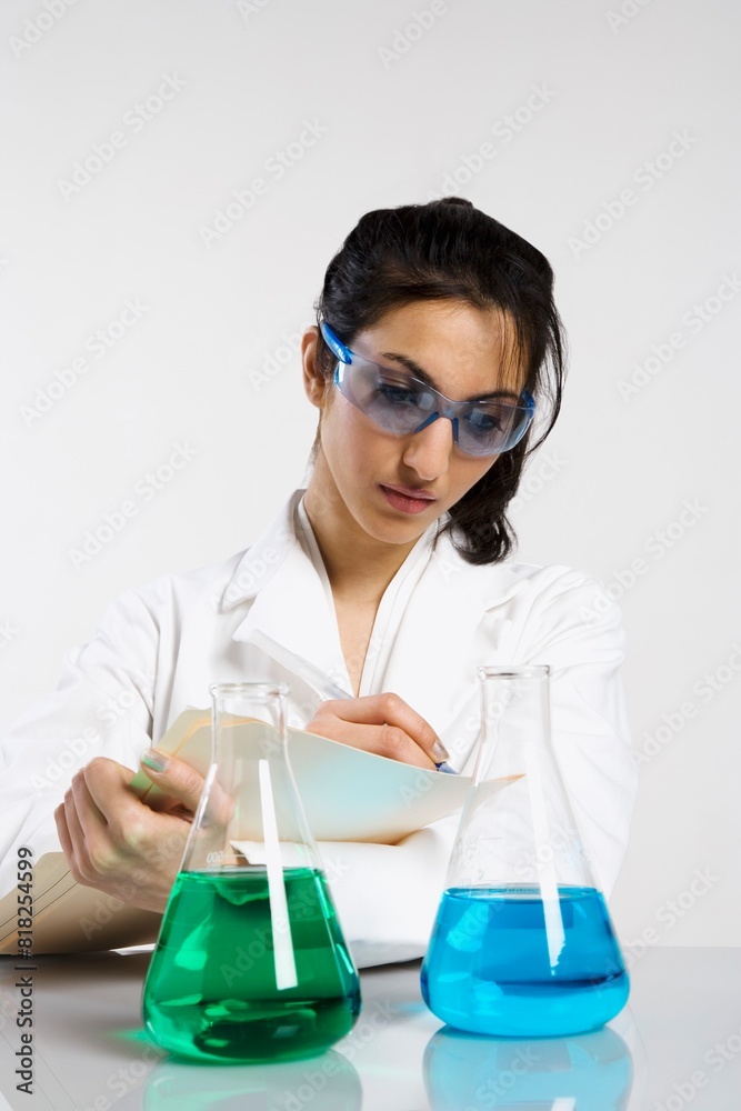 Woman Writing Results With Beakers Woman Writing Results With Beakers