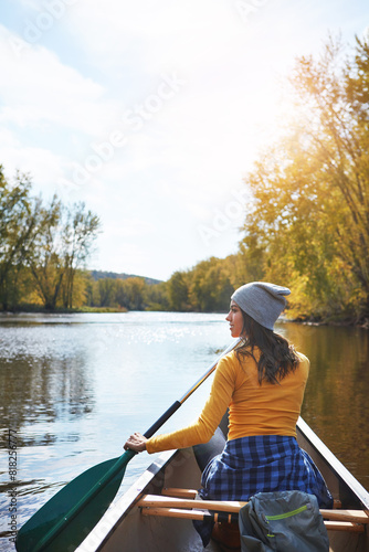 Woman, back and canoeing in forest on water, wellness hobby and backpack for supplies with paddle for rowing. Vacation, relax and explore exercise on travel holiday, canoe boat and trees on river © peopleimages.com