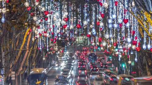 Avenida da Liberdade in Lisbon illuminated with lights hanging from the trees night timelapse. European street decorated for Christmas celebration. Traffic on the road during holiday evening. Portugal