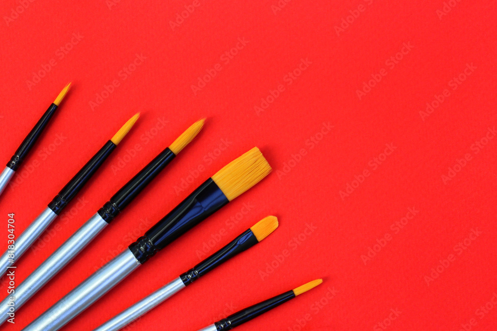 a set of brushes for drawing on a red background. synthetic brushes for watercolor, gouache, acrylic a set of brushes for drawing on a red background. synthetic brushes for watercolor, gouache, acrylic