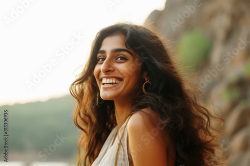portrait of a beautiful indian woman outside, glancing over her shoulder and laughing