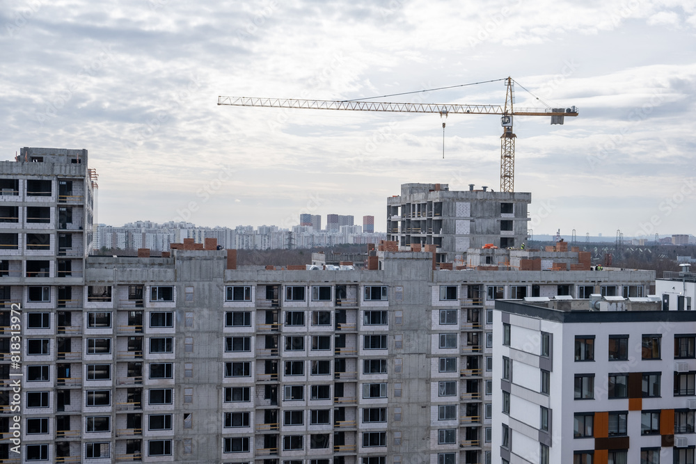 crane and a building under construction against a blue sky background crane and a building under construction against a blue sky background