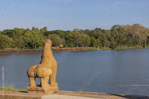 Historic Lion statue facing towards lake at Angkor Wat temple in Cambodia.