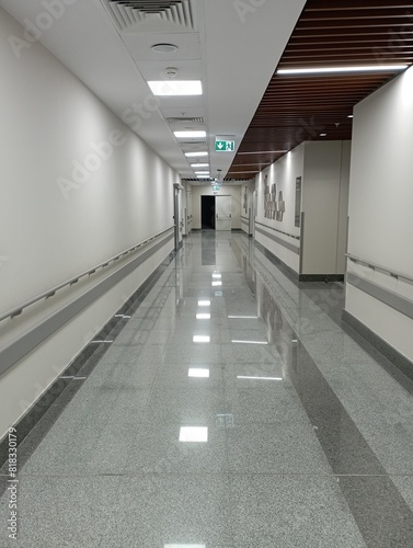 Empty modern hospital corridor, clinic hallway interior background with white chairs for patients waiting for doctor visit. Contemporary waiting room in medical office. Healthcare services concept