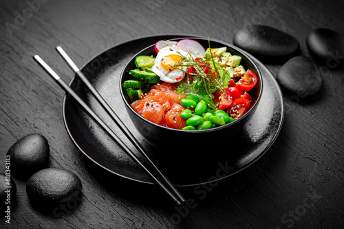 Salmon Poke bowl composition on black background. The Art of Japanese Cuisine. Food photography for menu and sushi bar decoration