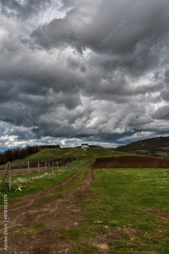 Sunny weather with beautiful and clear clouds in the sky. Heavy clouds over the hill with a house built on it. Pastures and forests on the mountain. Sunny weather with beautiful and clear clouds in the sky. Heavy clouds over the hill with a house built on it. Pastures and forests on the mountain.
