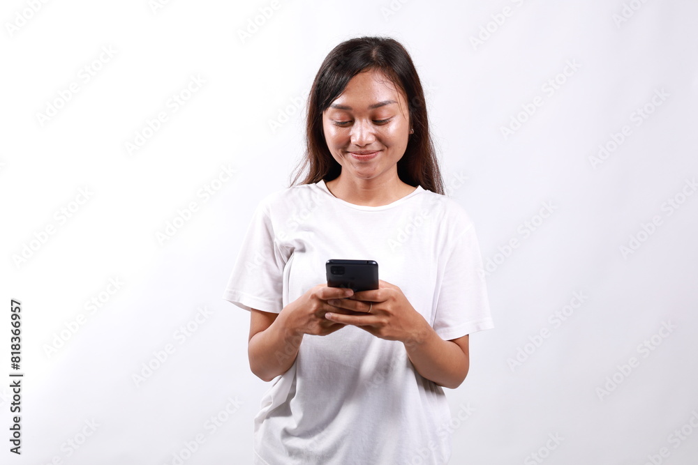 Smiling pleasant young asian woman standing using mobile phone. Isolated on white Smiling pleasant young asian woman standing using mobile phone. Isolated on white