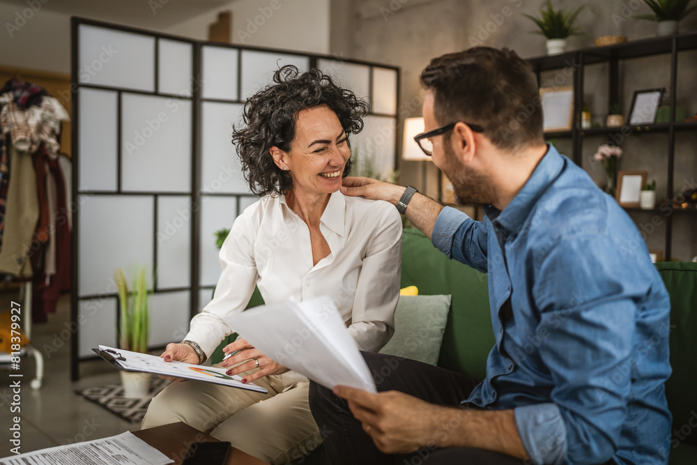 Fototapeta premium Two colleagues man and woman work on economy project together at home