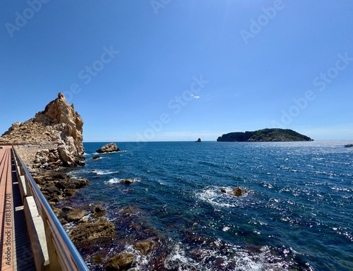 rocks at the Mediterranean Sea and a view towards the Illes Medes at the Cap de la Barra, Passeig Molinet near l'Estarit, Catalonia, Costa Brava, Girona, Spain   photo