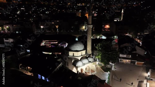 Night time aerial drone footage of Sarajevo Old Town of Baščaršija, with mosques and churches, car traffic and pedestrians walking. Country Bosnia and Herzegovina. photo