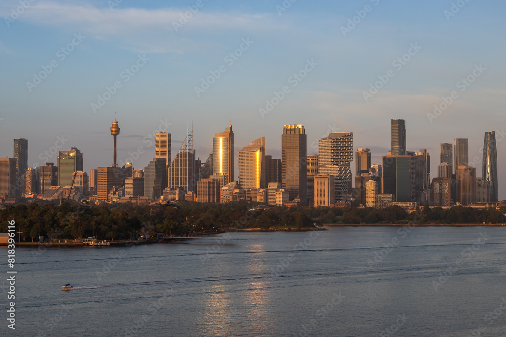 Fototapeta premium Extraordinary view of Sydney's Icons, namely the Sydney Opera House, Sydney Harbor Bridge and Sydney Downtown, while arriving by cruise ship in a beautiful sunrise.