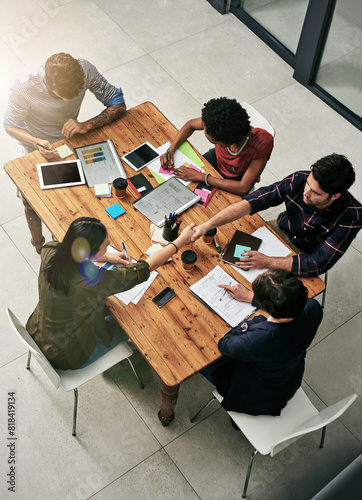 Meeting, business people and handshake in office for planning, discussion or company growth. Top view, lens flare and diverse staff with graphs for briefing, readership or subscription at publication