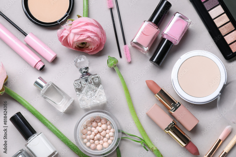 Flat lay composition with different makeup products and beautiful spring flowers on gray background Flat lay composition with different makeup products and beautiful spring flowers on gray background