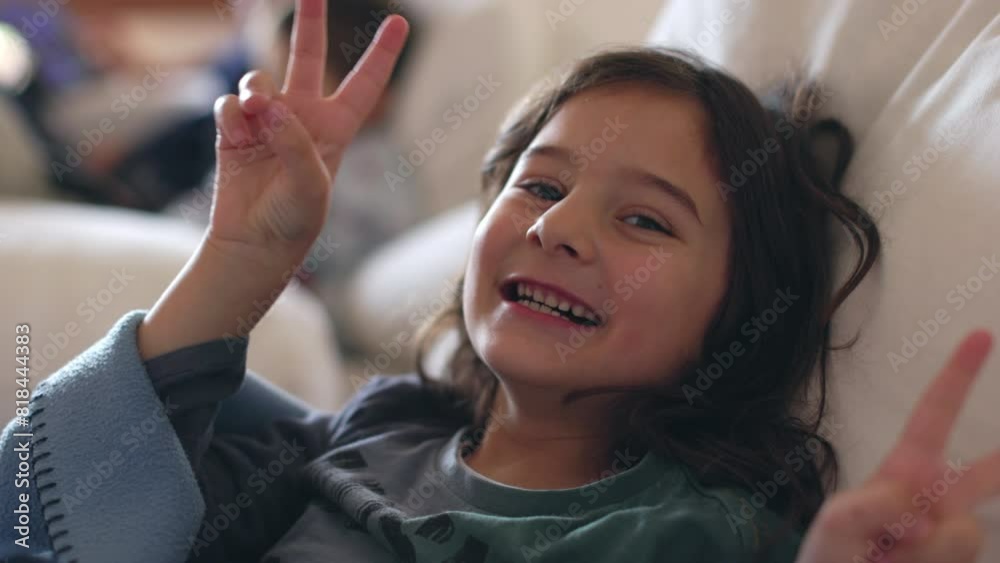 A young boy cheerfully smiling, wrapped in a blanket, relaxing on a couch during the day. A young boy cheerfully smiling, wrapped in a blanket, relaxing on a couch during the day.
