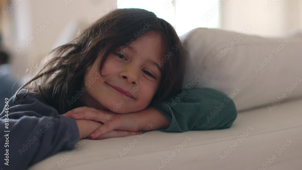 A young boy cheerfully smiling, wrapped in a blanket, relaxing on a couch during the day. A young boy cheerfully smiling, wrapped in a blanket, relaxing on a couch during the day.