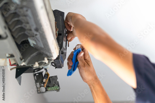Technician fix air conditioning temperature sensor, Repairman fix air conditioning systems, Male technicians service for repair and maintenance of air conditioners photo