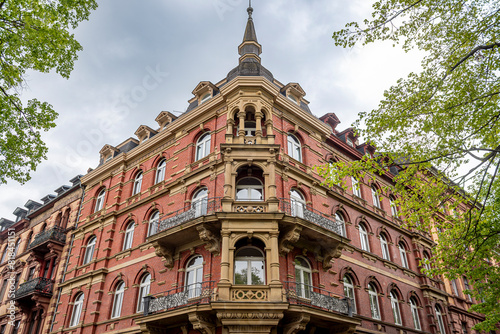Backsteinfassade eines luxuriösen Eckhauses der Gründerzeit mit Balkonen und Verzierungen in Unteransicht photo
