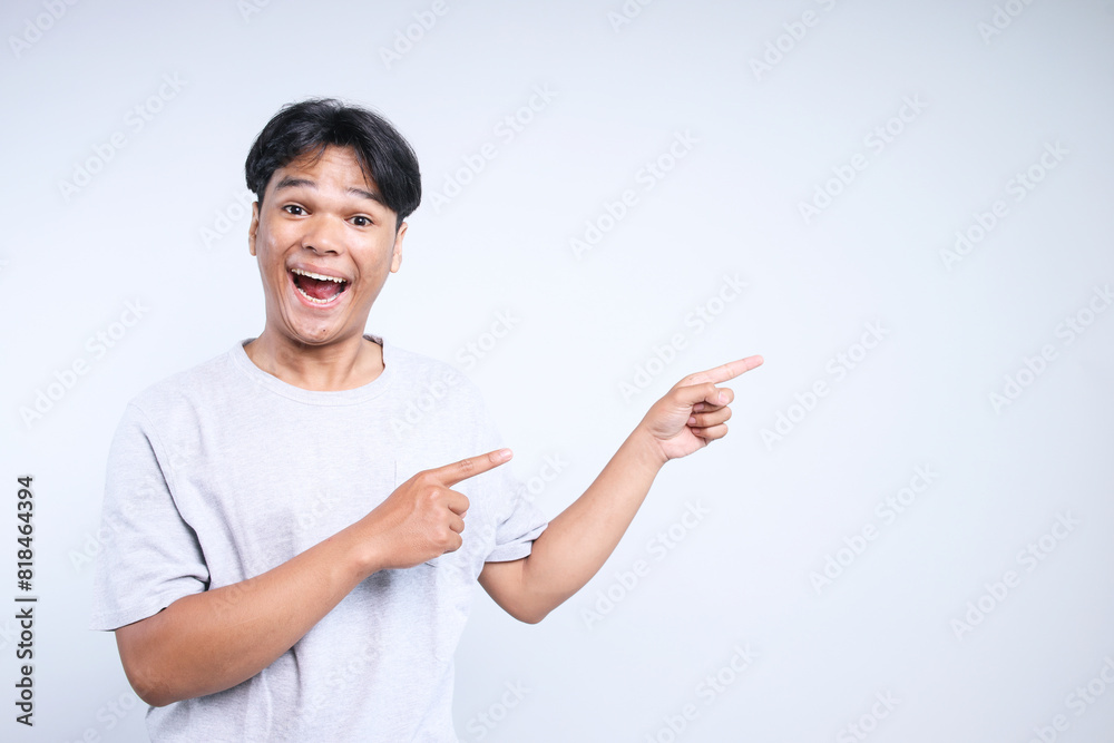 Potrait Of Excited Young Asian Guy Pointing To Side For Advertisement Isolated On White Background Potrait Of Excited Young Asian Guy Pointing To Side For Advertisement Isolated On White Background