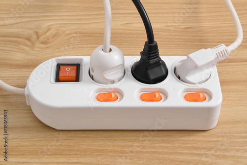 Electrical plug in outlet socket at home isolated on on wooden table, Outlet, Electric Plug, Power Cable, a power button and a connected electrical plug