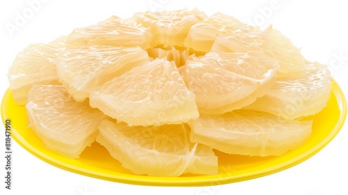 Sliced fresh pomelo segments arranged on a yellow plate, showcasing the juicy, translucent fruit pieces in a vibrant presentation. photo