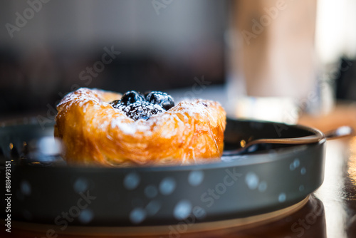 Close up sweet blueberry danish pastry on black dish. Selective focus