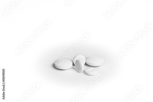 Five white generic pills next to each other on white background.