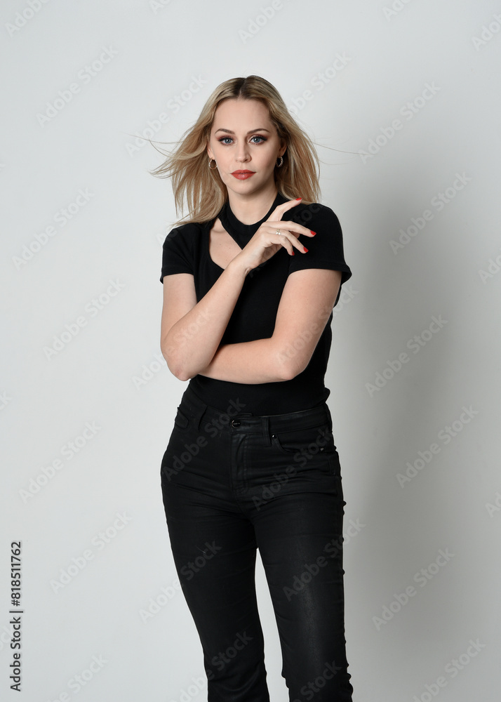 Close up portrait of beautiful blonde woman wearing modern black shirt and leather pants. Confident standing pose with hand gestures, isolated on white studio background. Close up portrait of beautiful blonde woman wearing modern black shirt and leather pants. Confident standing pose with hand gestures, isolated on white studio background.