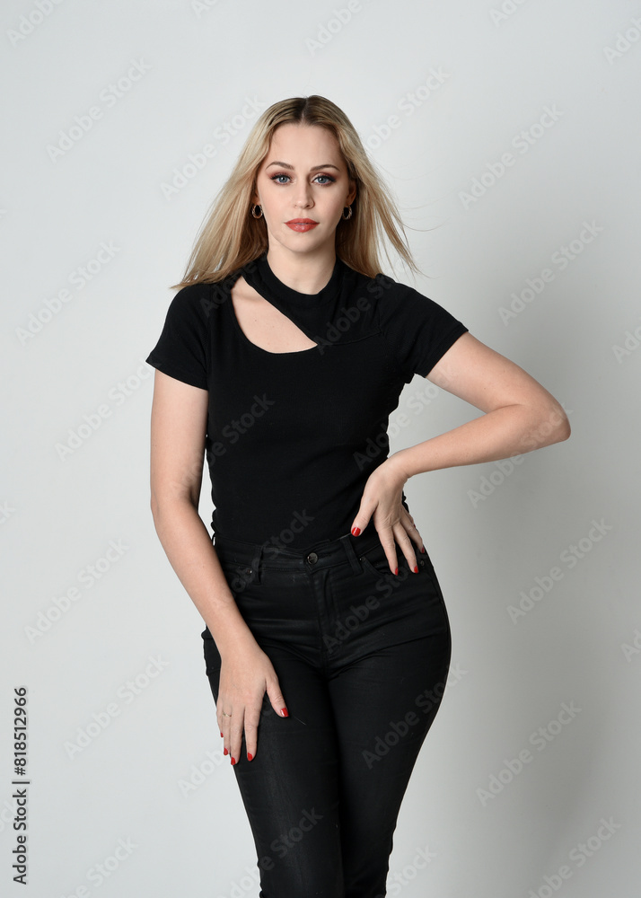 Close up portrait of beautiful blonde woman wearing modern black shirt and leather pants. Confident standing pose with hand gestures, isolated on white studio background. Close up portrait of beautiful blonde woman wearing modern black shirt and leather pants. Confident standing pose with hand gestures, isolated on white studio background.