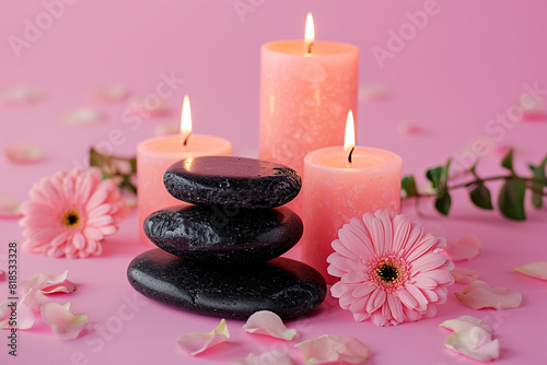Zen black stones, flowers and aromatic candles on pink table. Spa still life