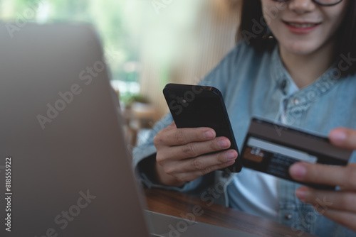 Smiling young asian woman using mobile phone and credit card for mobile banking, digital payment via mobile app. Happy user using smartphone for internet payment, financial technology