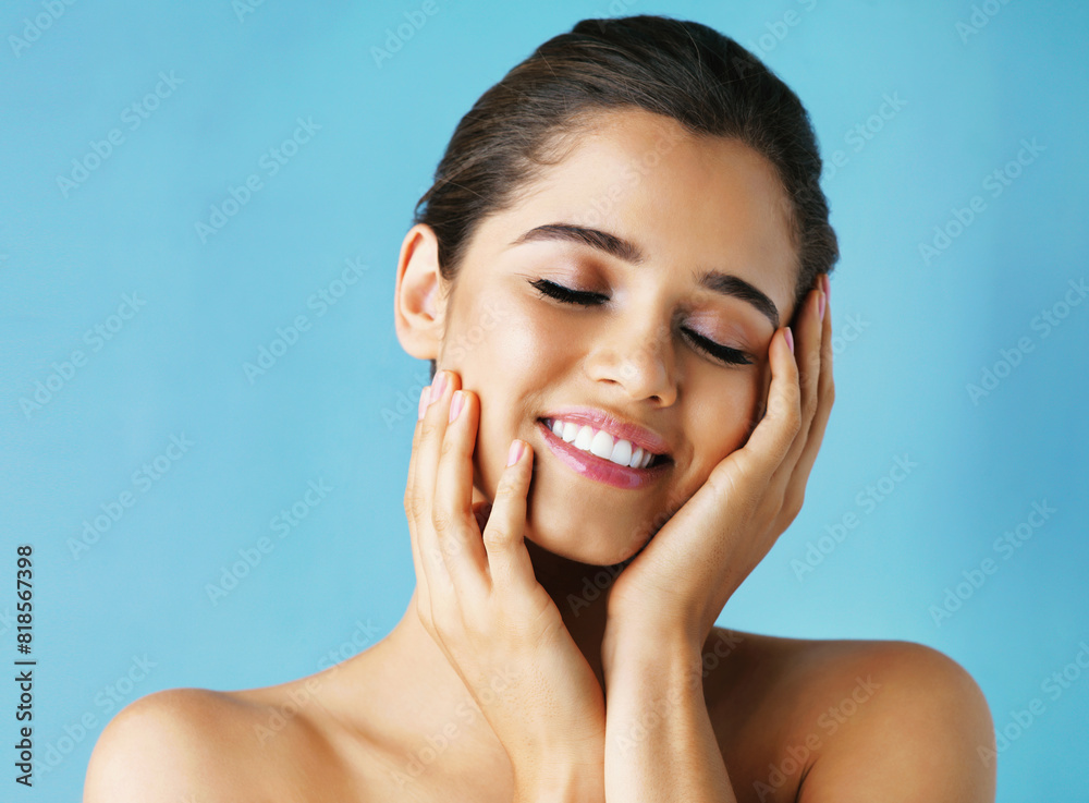 Happy woman, beauty and makeup with skincare in satisfaction for facial on a blue studio background. Face of calm female person or model with smile in relax for cosmetics, dermatology or cosmetology